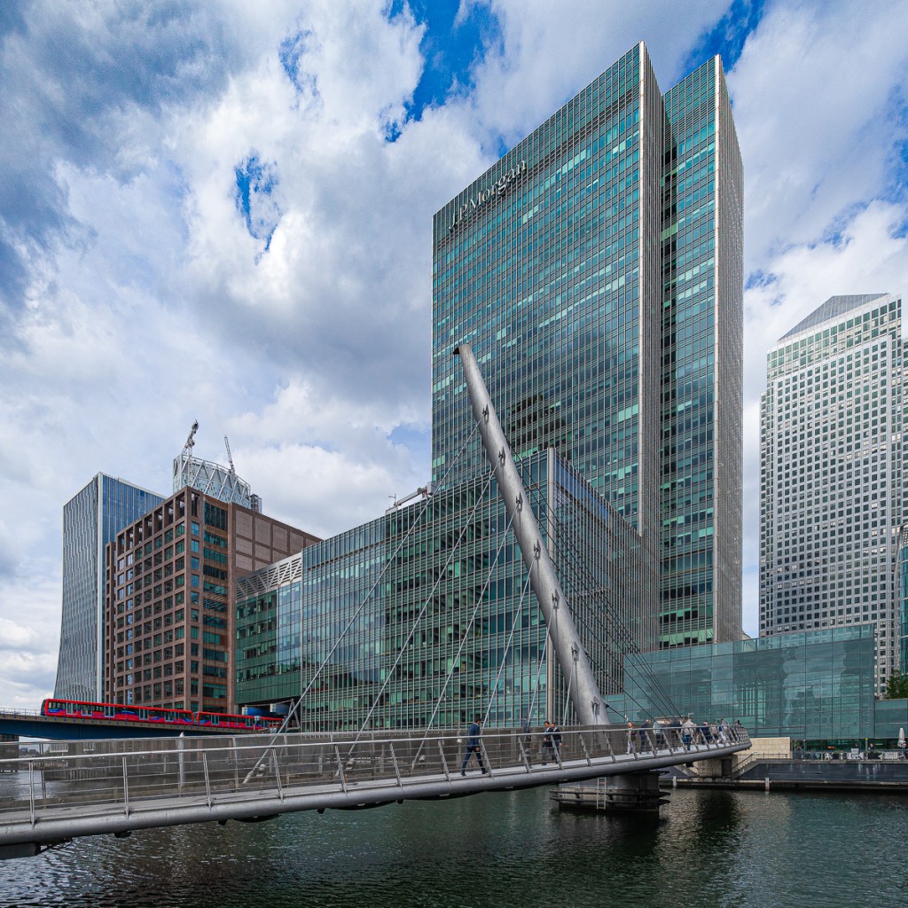 A red DLR train makes a splash of red against the urban backdrop of Canary Wharf