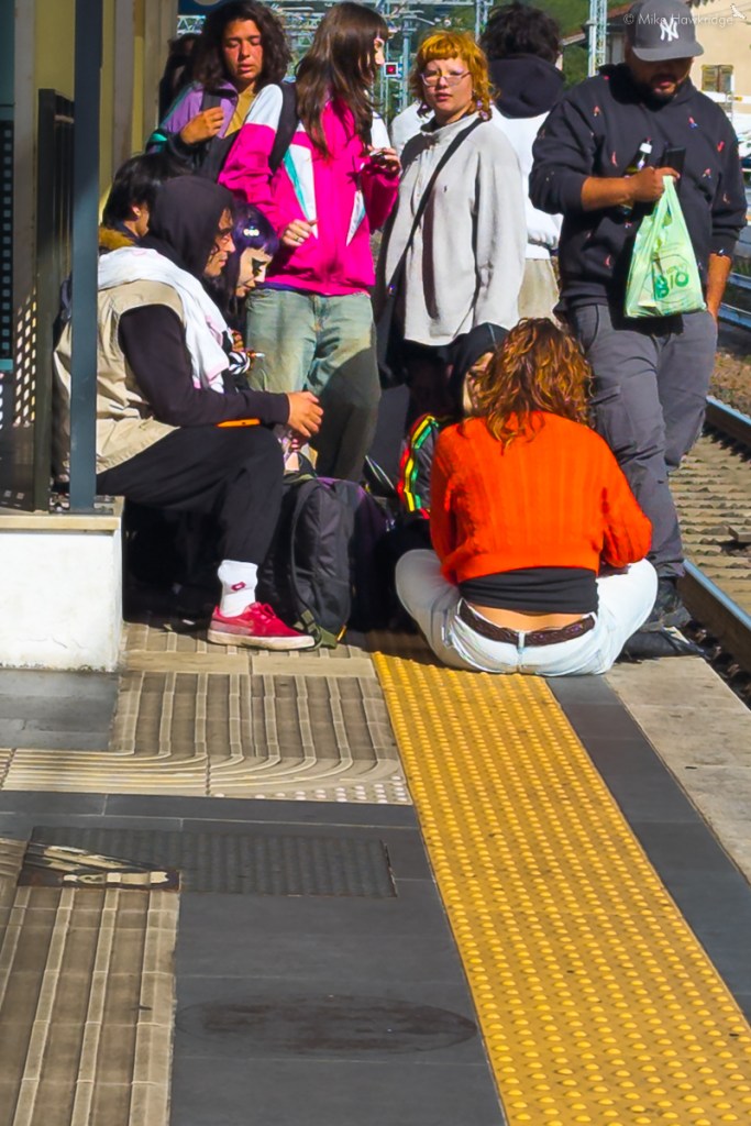 sitting on a station platform the wrong side of the yellow line in italy
